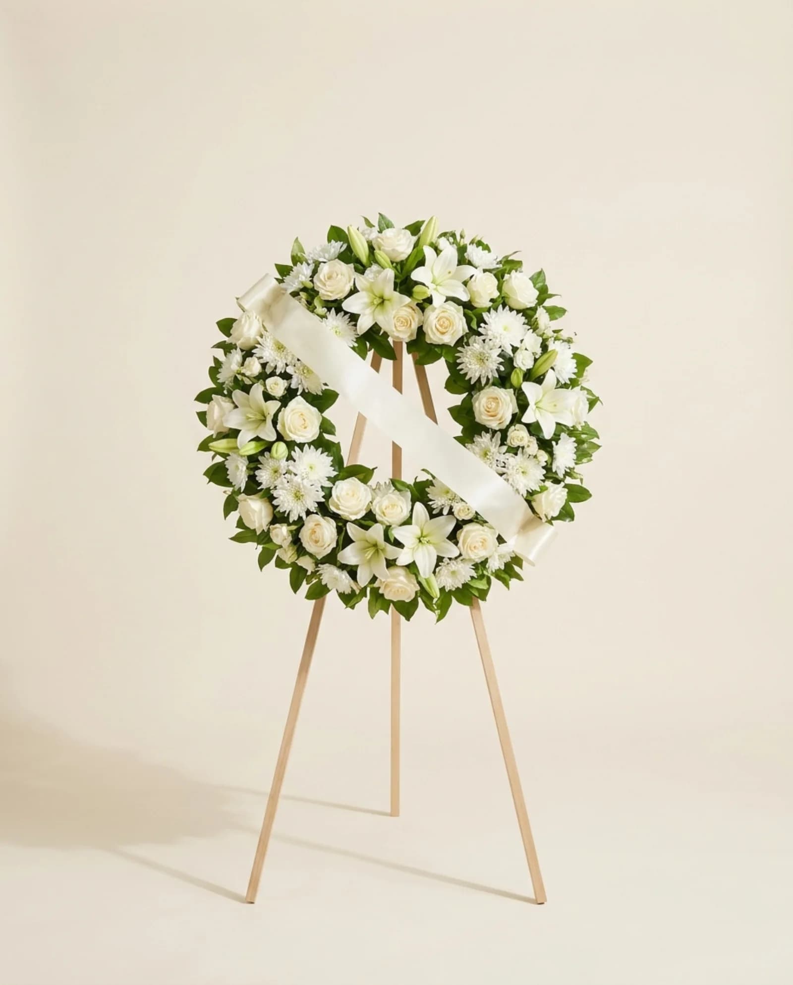 Coroa de flores brancas em tripé, com laço.